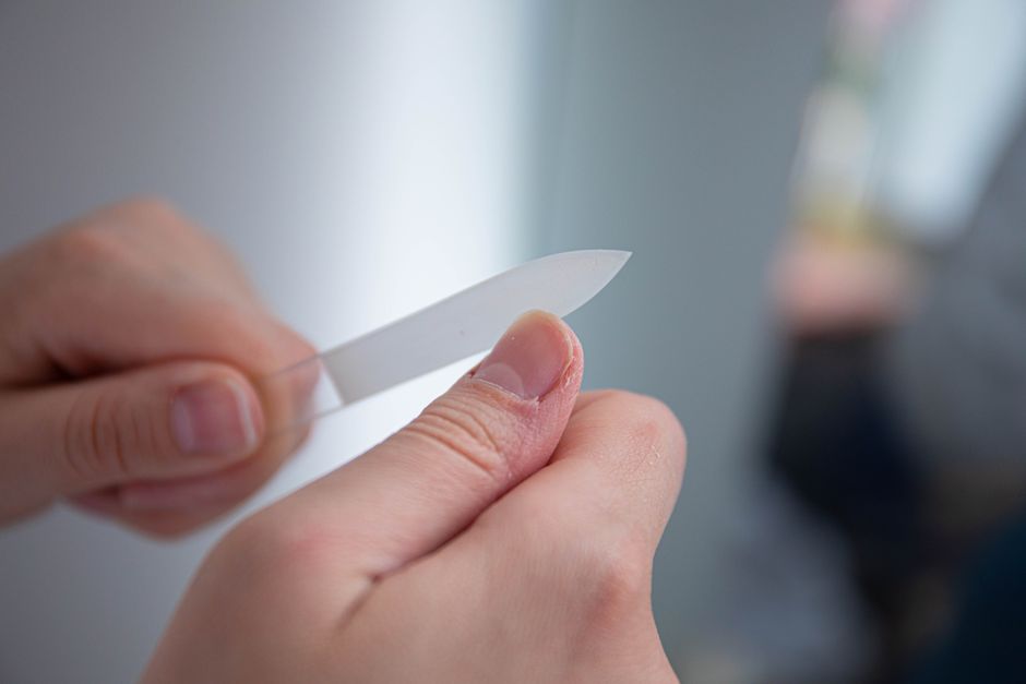 Mani con unghie naturali curate e lucide, che simboleggiano salute e bellezza