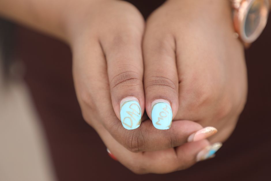 Primo piano di mani con unghie decorate con elaborate nail art colorate e brillanti