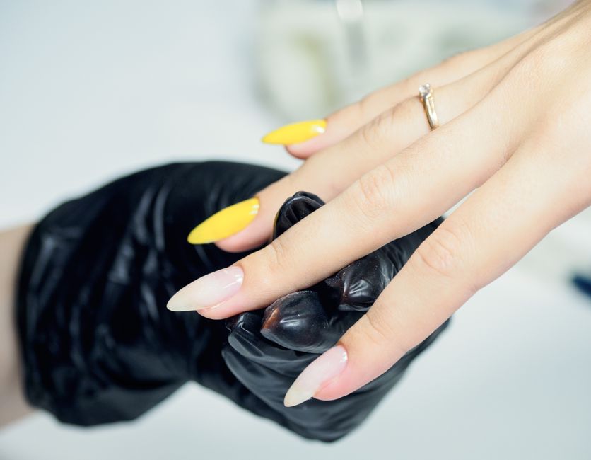 Mani di una modella con unghie ricostruite in gel perfette e brillanti, curate da un'onicotecnica professionista.